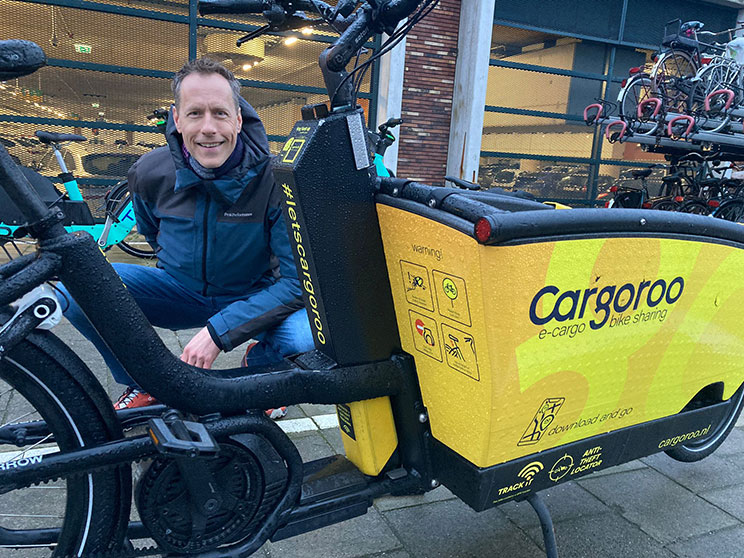 Joep Trappenburg gehurkt bij Cargoroo deelbakfiets.